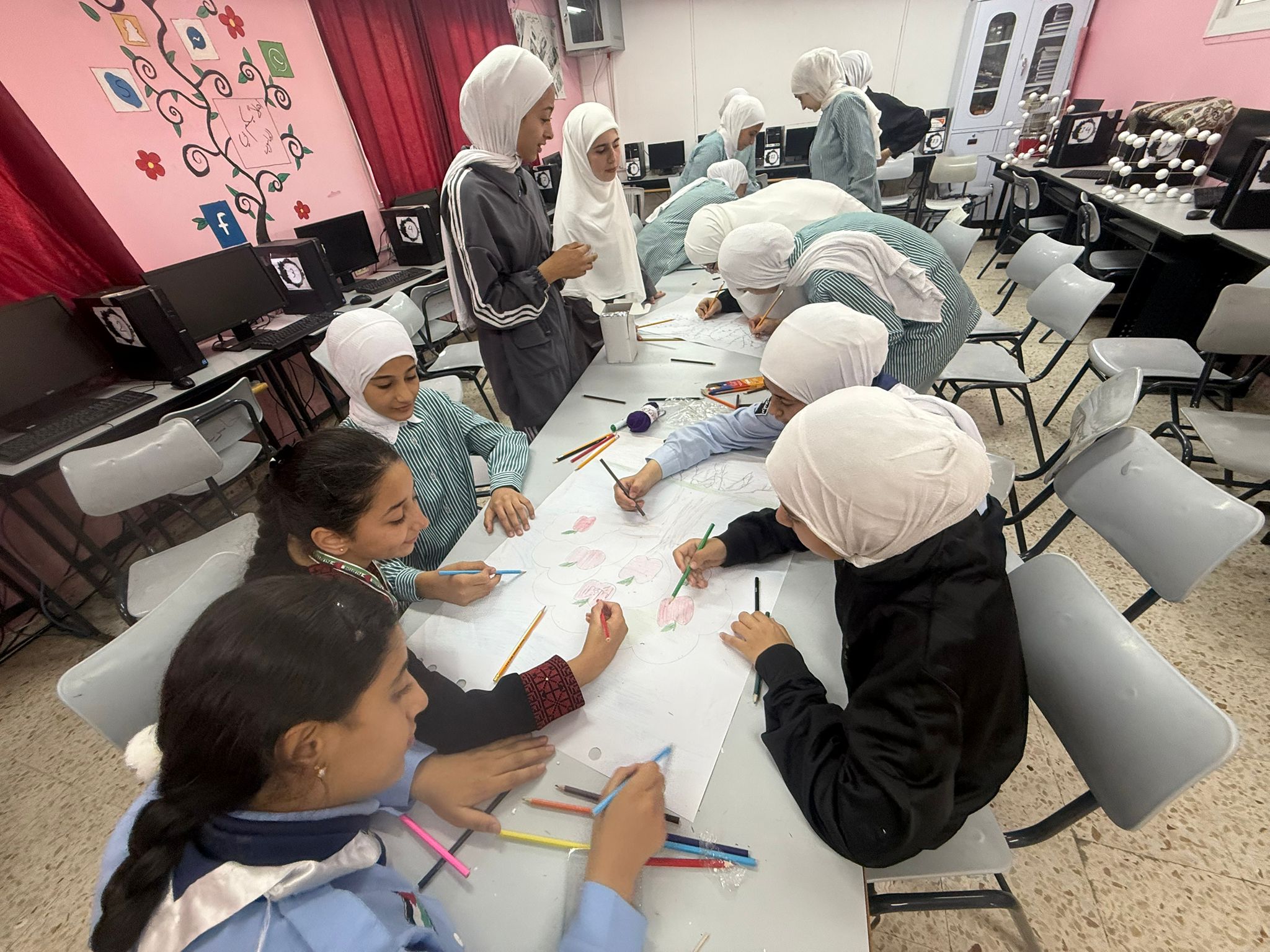 Grupo de rapazas traballando ao redor dunha mesa en Palestina
